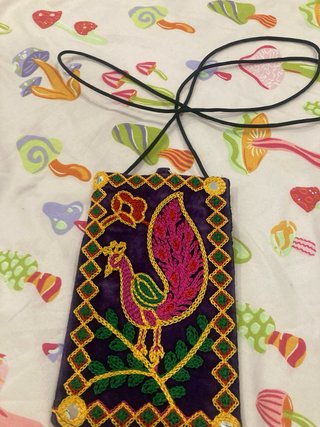 Bolso étnico morado con bordado de pavo real