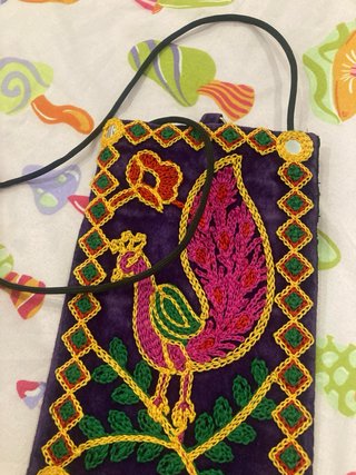Bolso étnico morado con bordado de pavo real