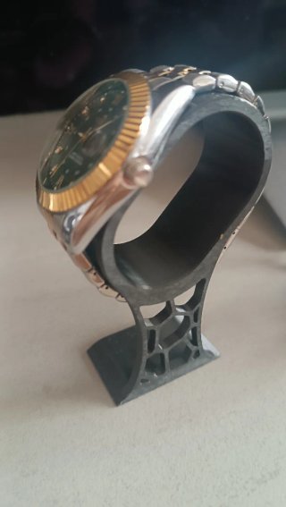 Reloj de pulsera con esfera verde y detalles dorad