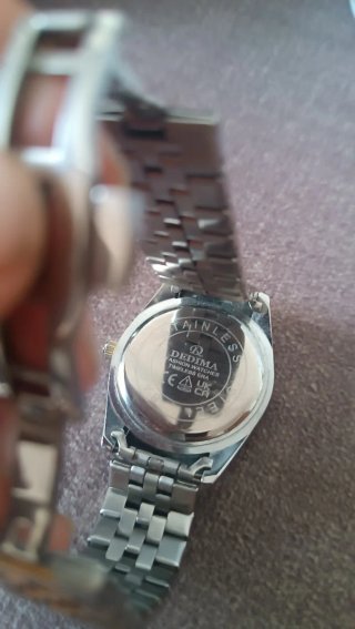 Reloj de pulsera con esfera verde y detalles dorad