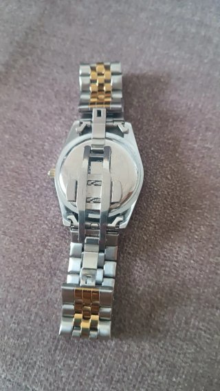 Reloj de pulsera con esfera verde y detalles dorad