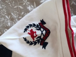 Polo blanco y azul con escudo