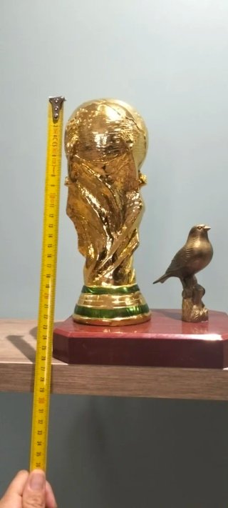Trofeo dorado con pájaro decorativo