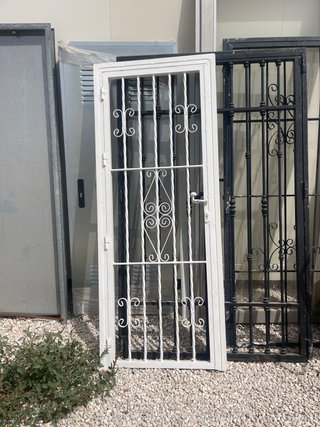 Puerta de reja blanca con barrotes