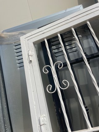 Puerta de reja blanca con barrotes