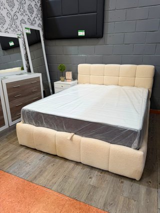 Cama tapizada beige con cabecero