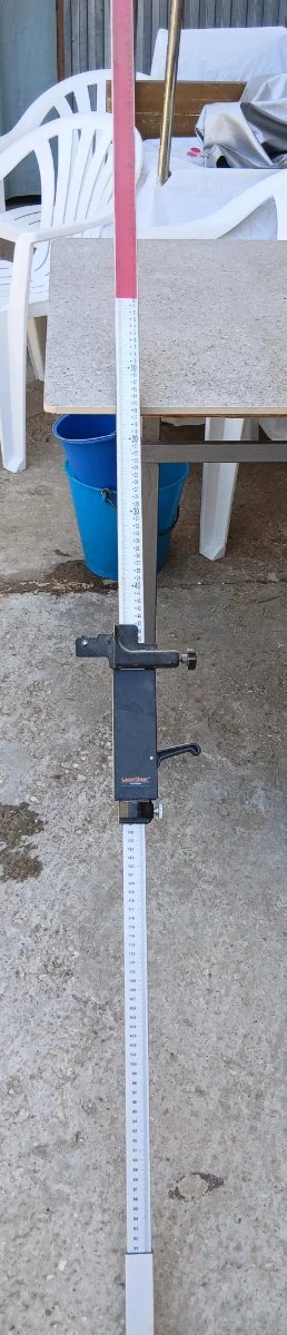 Nivel láser con trípode y regla