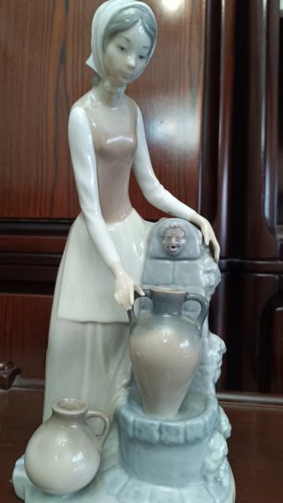 Figura de porcelana niña en la fuente