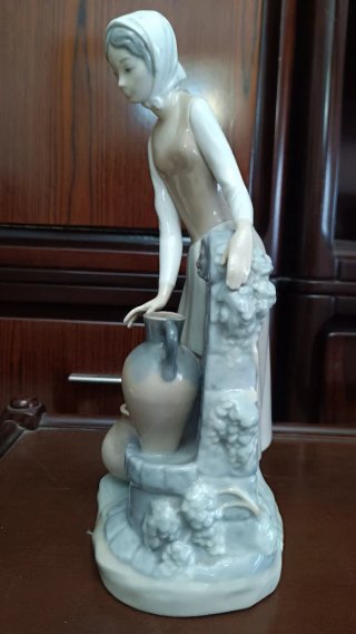 Figura de porcelana niña en la fuente