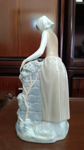Figura de porcelana niña en la fuente