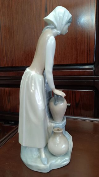 Figura de porcelana niña en la fuente
