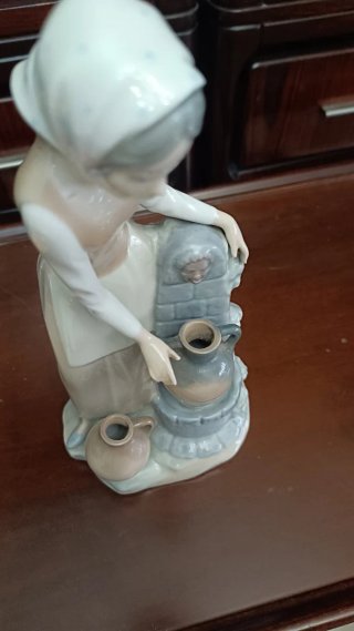 Figura de porcelana niña en la fuente