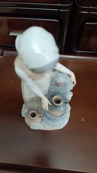 Figura de porcelana niña en la fuente