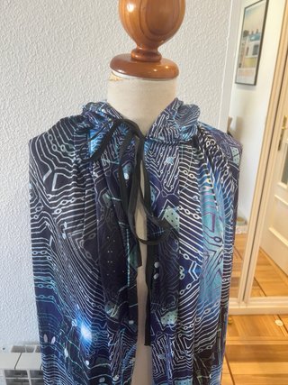 Capa con capucha azul y estampado galáctico