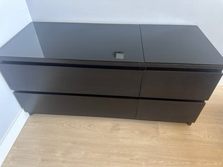 Cómoda de cajones de madera y cristal sobre puesto