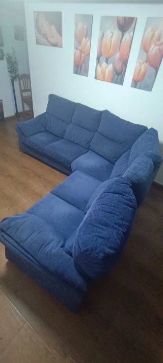 Sofá esquinero azul de tela.
