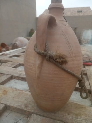 Botija de barro antigua con asas y cuerda