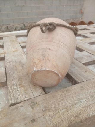 Botija de barro antigua con asas y cuerda