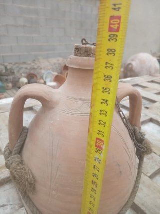 Botija de barro antigua con asas y cuerda