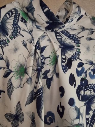 Blusa smanicata con farfalle e fiori