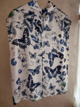 Blusa smanicata con farfalle e fiori