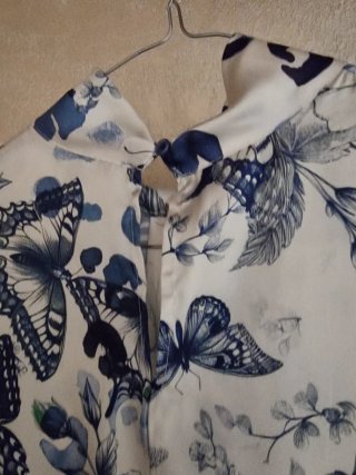 Blusa smanicata con farfalle e fiori