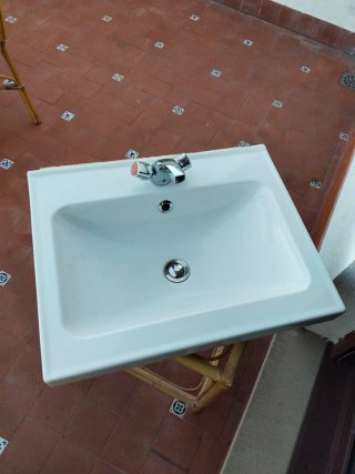 Lavabo de cerámica con grifo y mueble