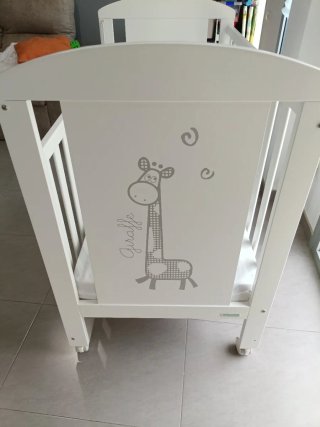 Cuna de bebé blanca con jirafa