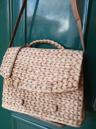 Bolso tejido de rafia con correa de piel.