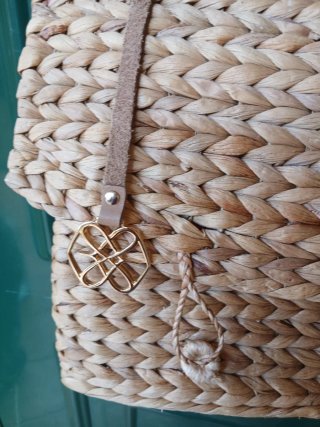 Bolso tejido de rafia con correa de piel.