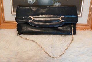 Bolso  negro con cadena y detalles metálicos.