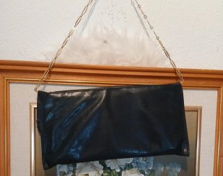 Bolso  negro con cadena y detalles metálicos.