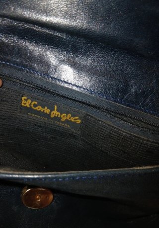 Bolso  negro con cadena y detalles metálicos.