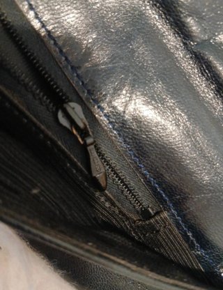 Bolso  negro con cadena y detalles metálicos.