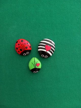 Coccinelle portafortuna dipinte a mano su sassi.