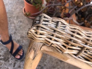 Sillón de mimbre con cojín blanco