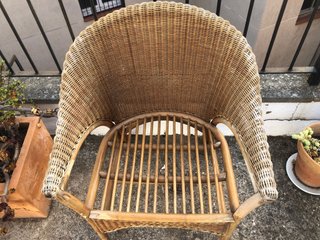 Sillón de mimbre con cojín blanco