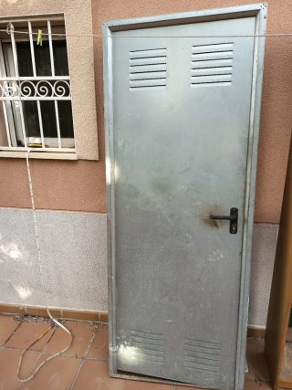 Puerta metálica con ventilación y cerradura.
