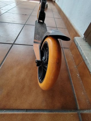 Patinete negro con ruedas naranjas