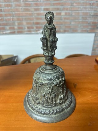 Campana antigua con figura religiosa