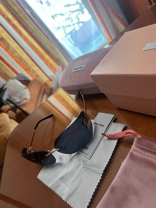 Gafas de sol Miu Miu negras y doradas