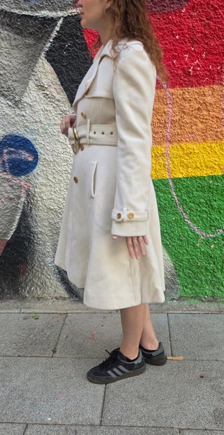 Abrigo estilo trench blanco con cinturón dorado