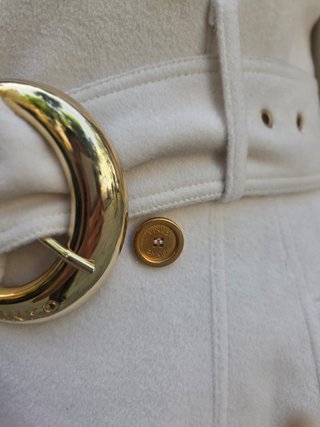 Abrigo estilo trench blanco con cinturón dorado