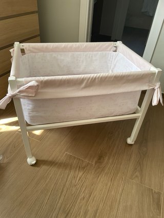 Cuna de bebé con ruedas y textiles