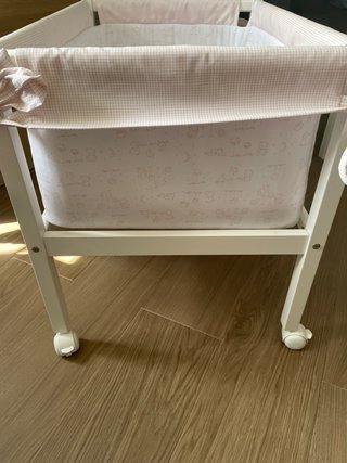 Cuna de bebé con ruedas y textiles