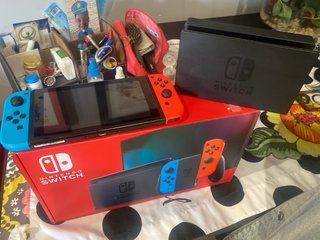 Nintendo Switch Rojo, Azul y Naranja en su caja.