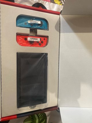 Nintendo Switch Rojo, Azul y Naranja en su caja.