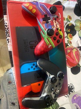 Nintendo Switch Rojo, Azul y Naranja en su caja.