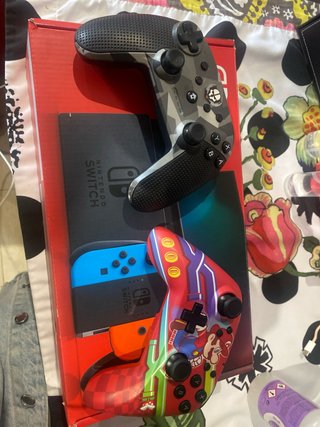 Nintendo Switch Rojo, Azul y Naranja en su caja.