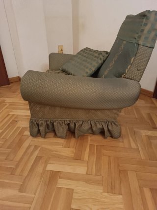 Sillón de tela verde con cojín